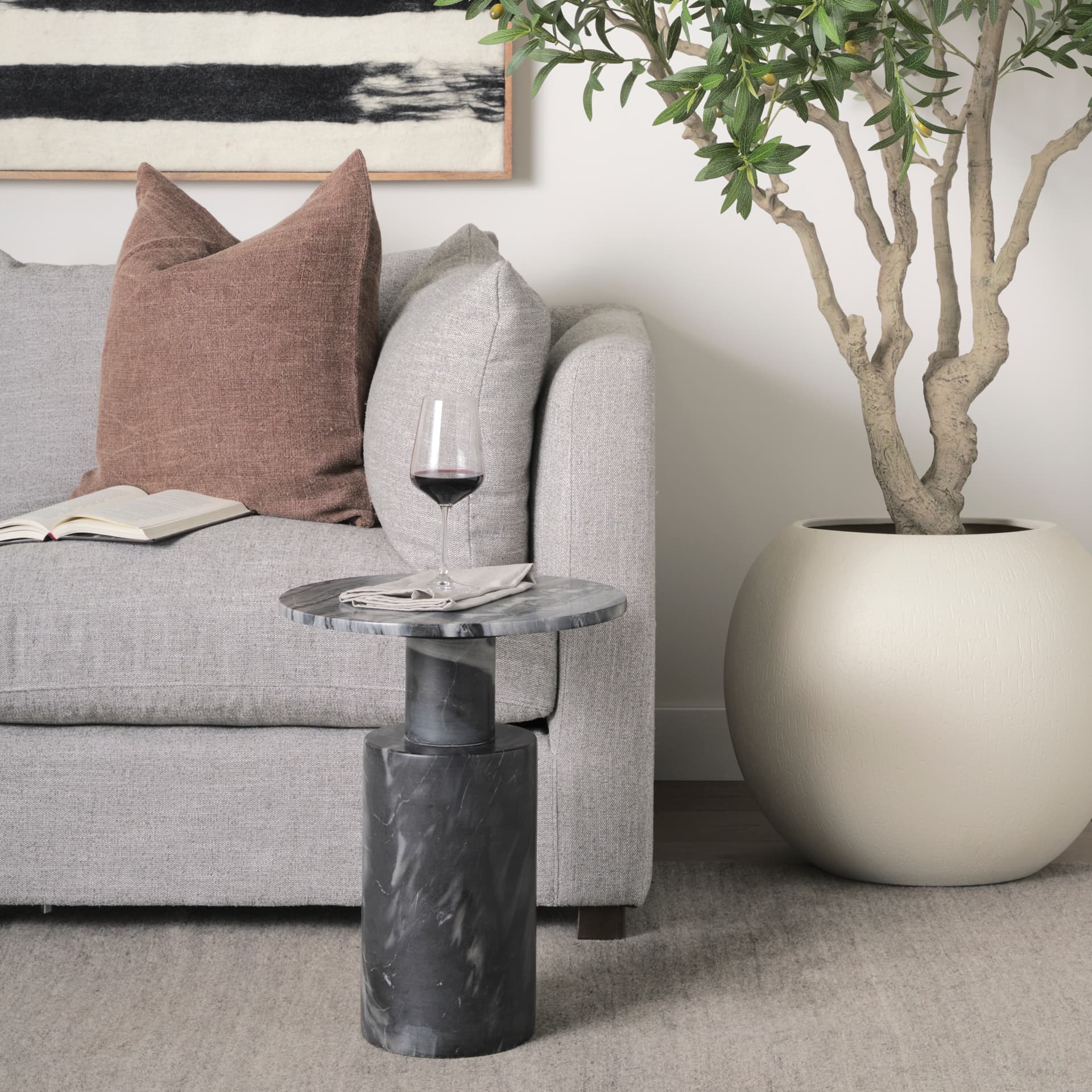 Taite Solid Dark Gray Marble Pedestal Accent Table — in a styled room