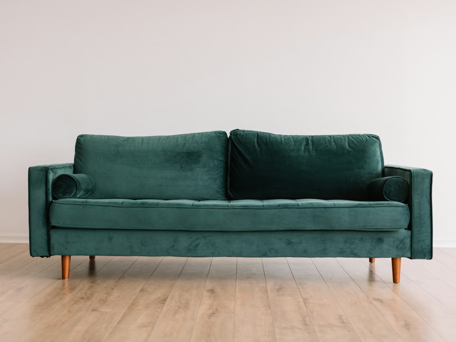 Aster three-seat sofa in forest velvet against a white wall