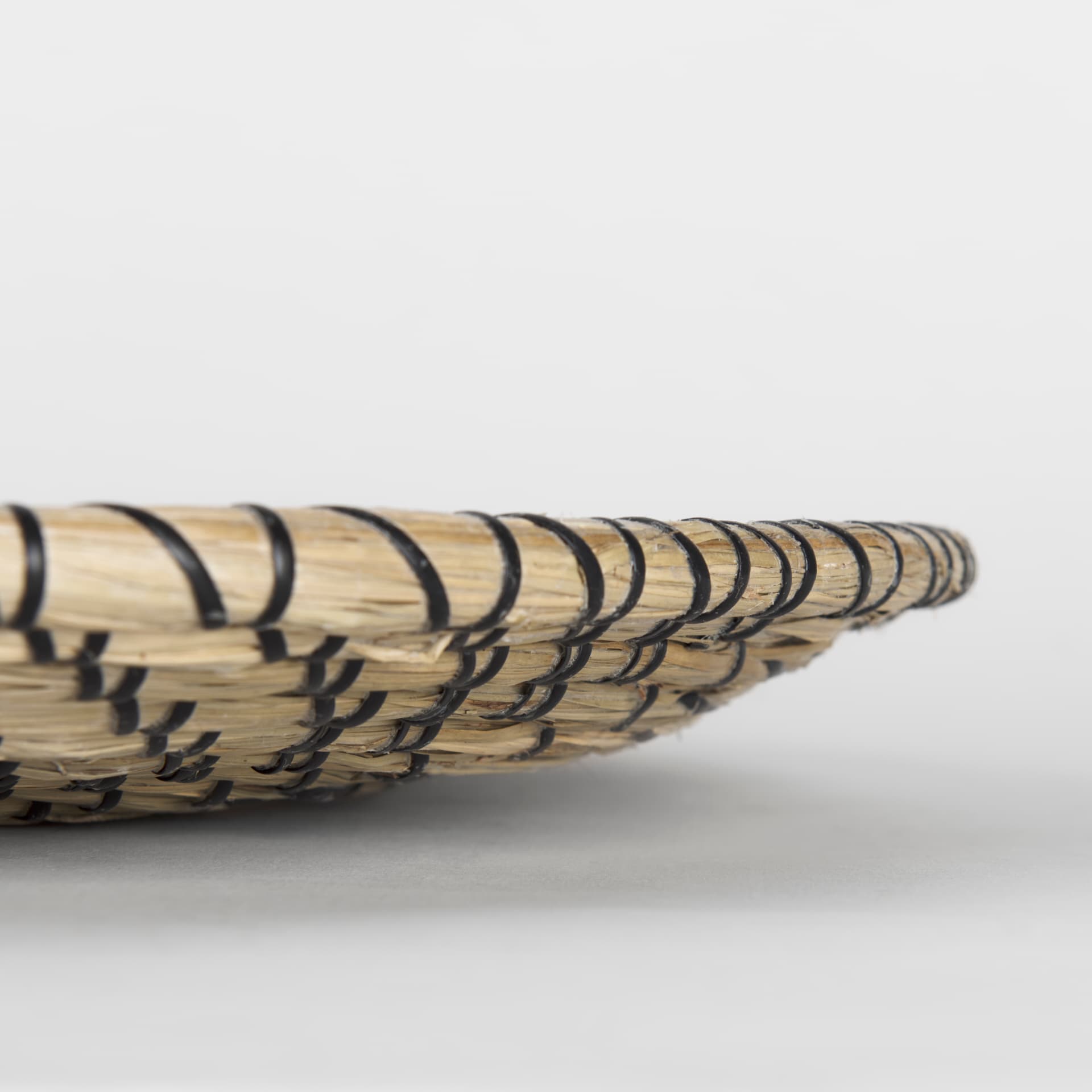 Mekhi 24.0L x 24.0W x 3.5 Light Brown Seagrass W/Black String Round Wall Hanging Plate — product photograph