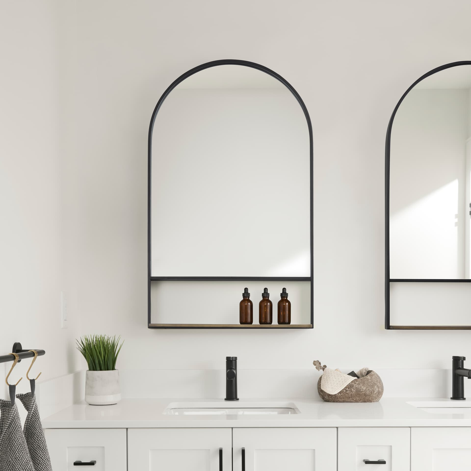 Cora 24.0L x 3.9W x 40.0H Black Metal Frame W/ Brown Wooden Shelf Arched Wall Mirror — in a styled room