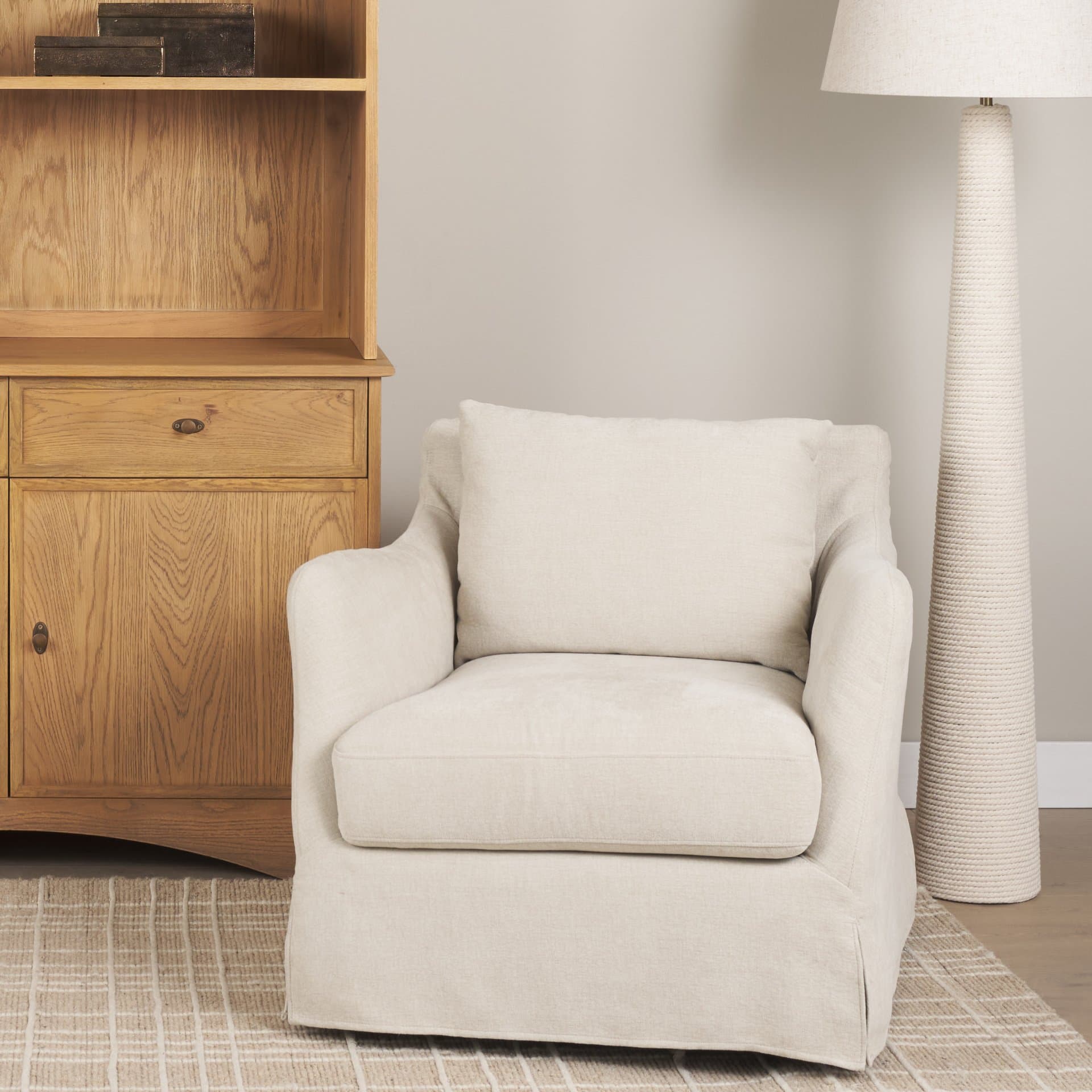 Ellington Slipcovered Slope Arm Swivel Swivel Accent Chair | Cream Fabric — in a styled room