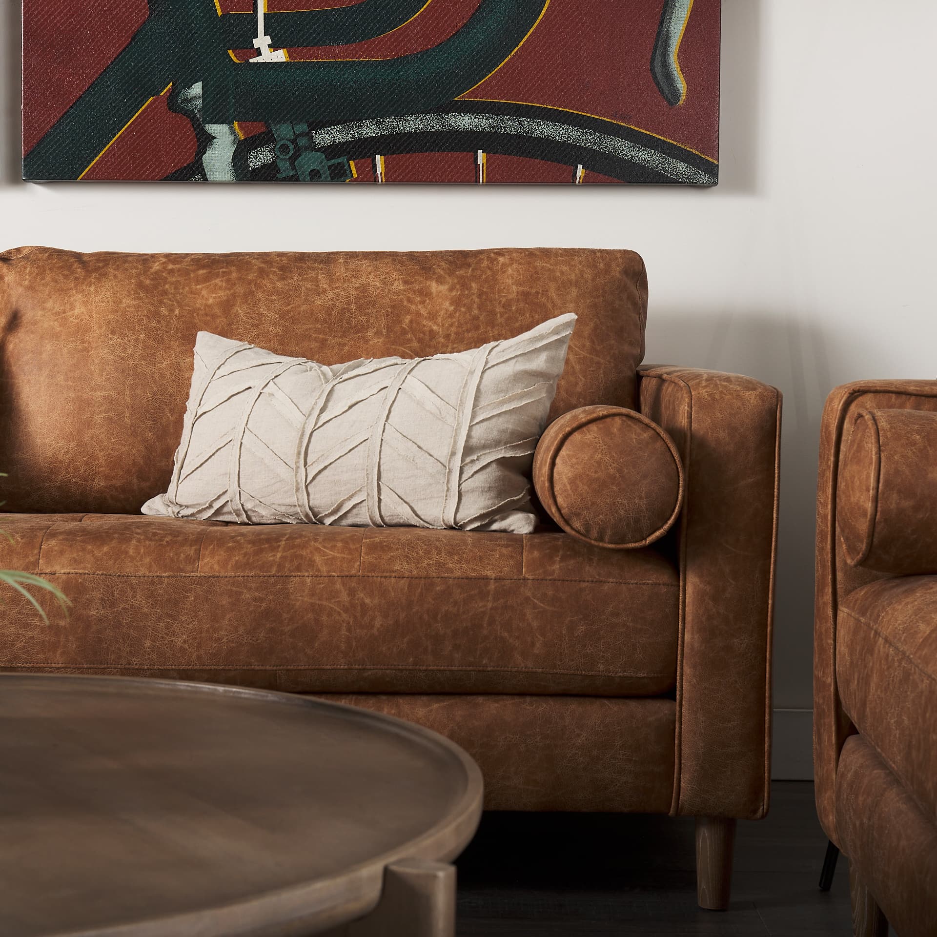 Loretta 88.0L x 36.2W x 33.9H Cognac Brown Faux Leather Three Seater Sofa with Two Bolster Cushions — product photograph