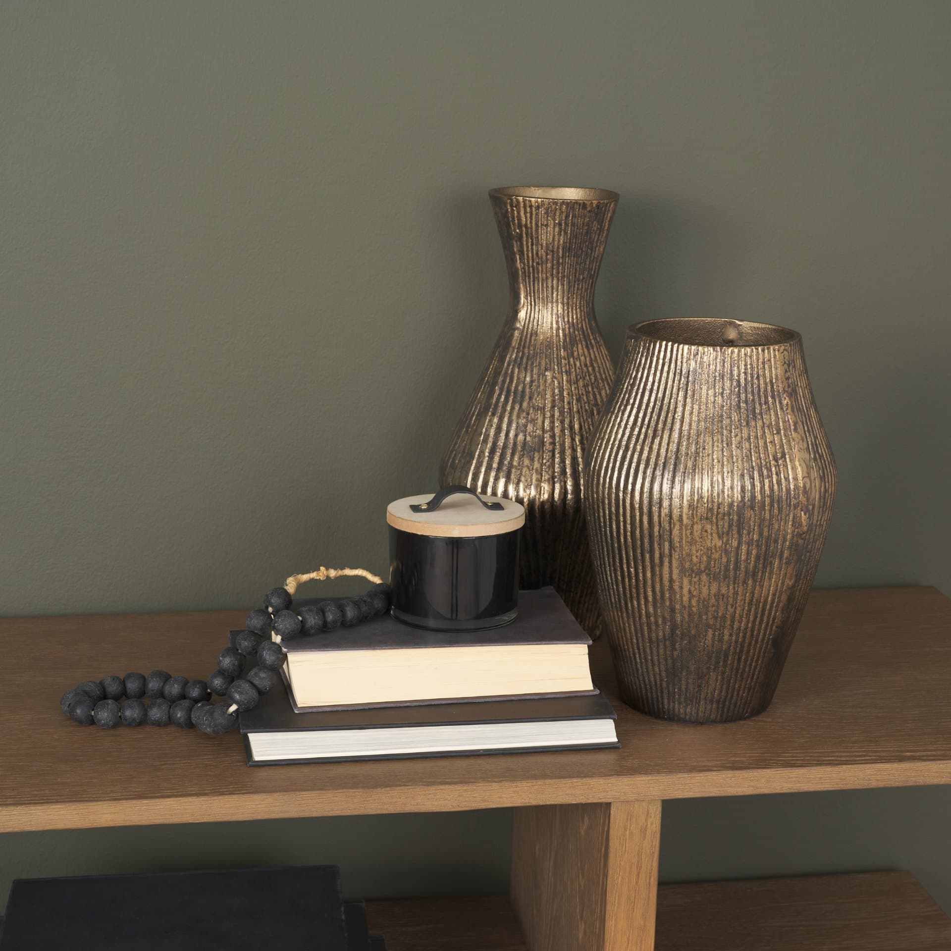 Patine Antiqued Brass Metal Fluted Hourglass Decorative Vase — in a styled room