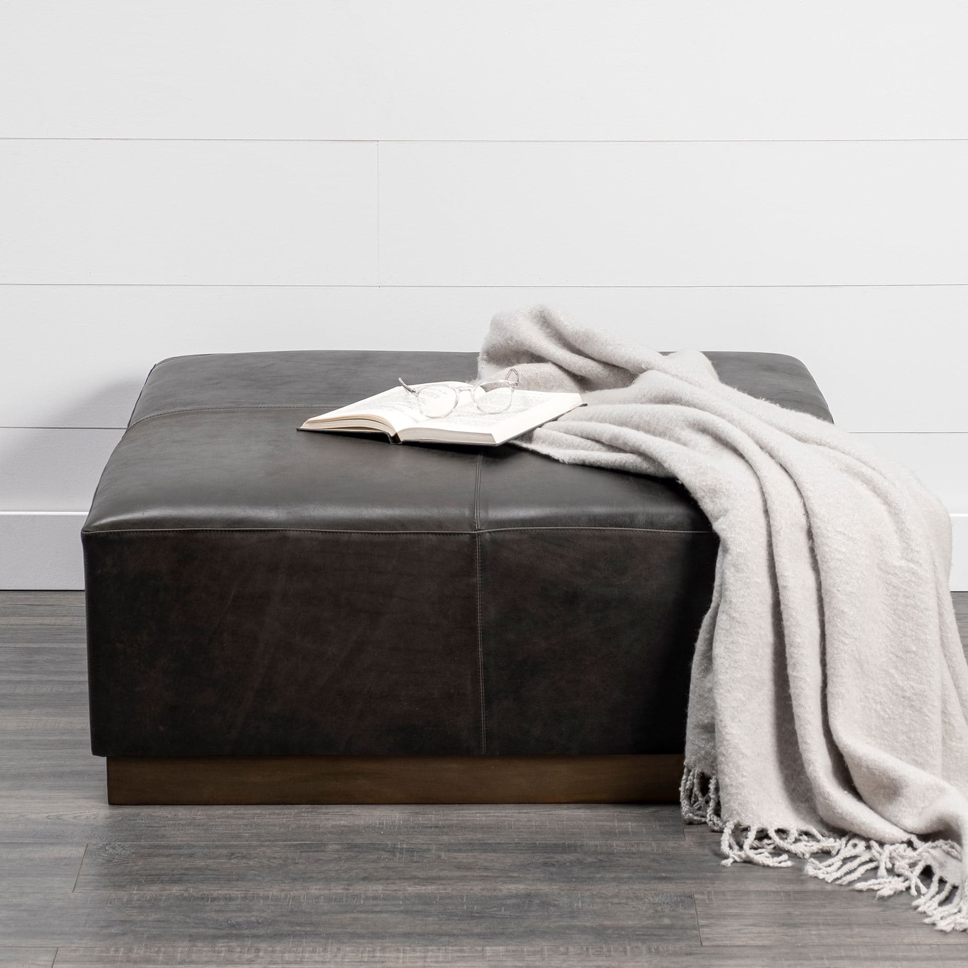 Minara 36" Square Black Leather Wrapped w/Metal Base Ottoman — in a styled room