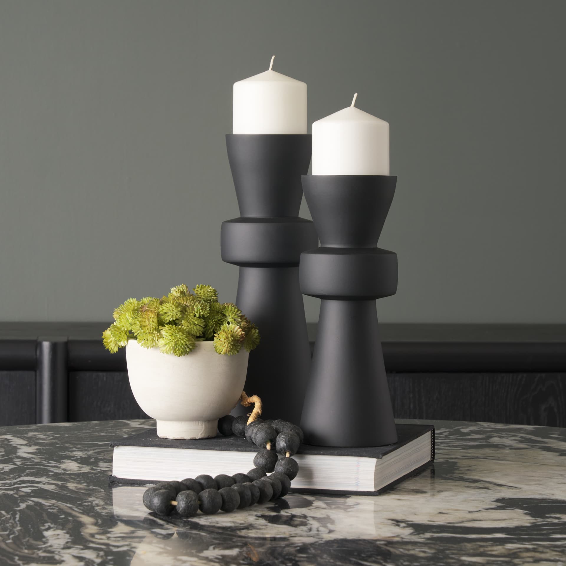 Odilia Small Smooth Matte Black Metal Geometric Pillar Candle Holder — in a styled room