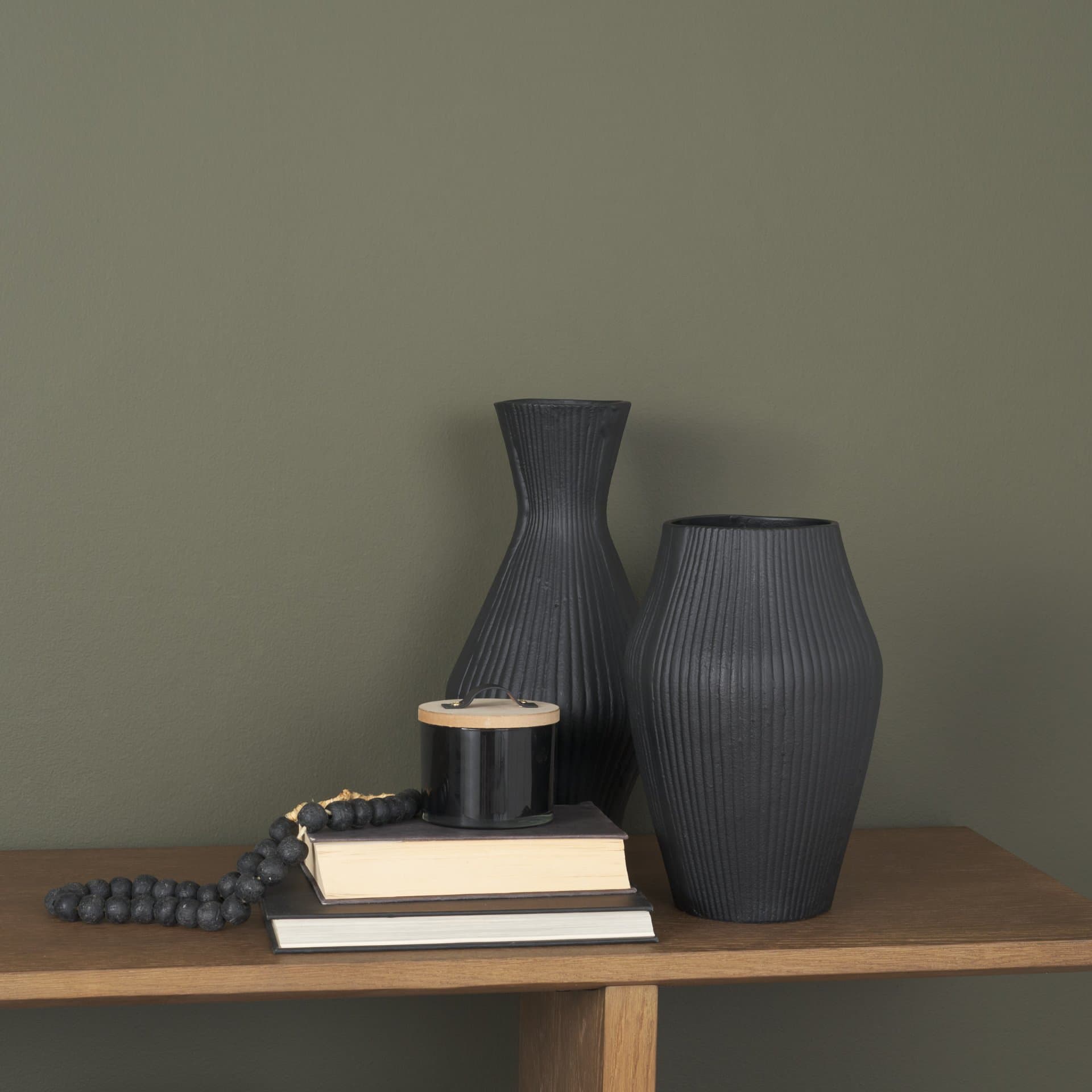 Patine Matte Black Metal Fluted Hourglass Decorative Vase — in a styled room