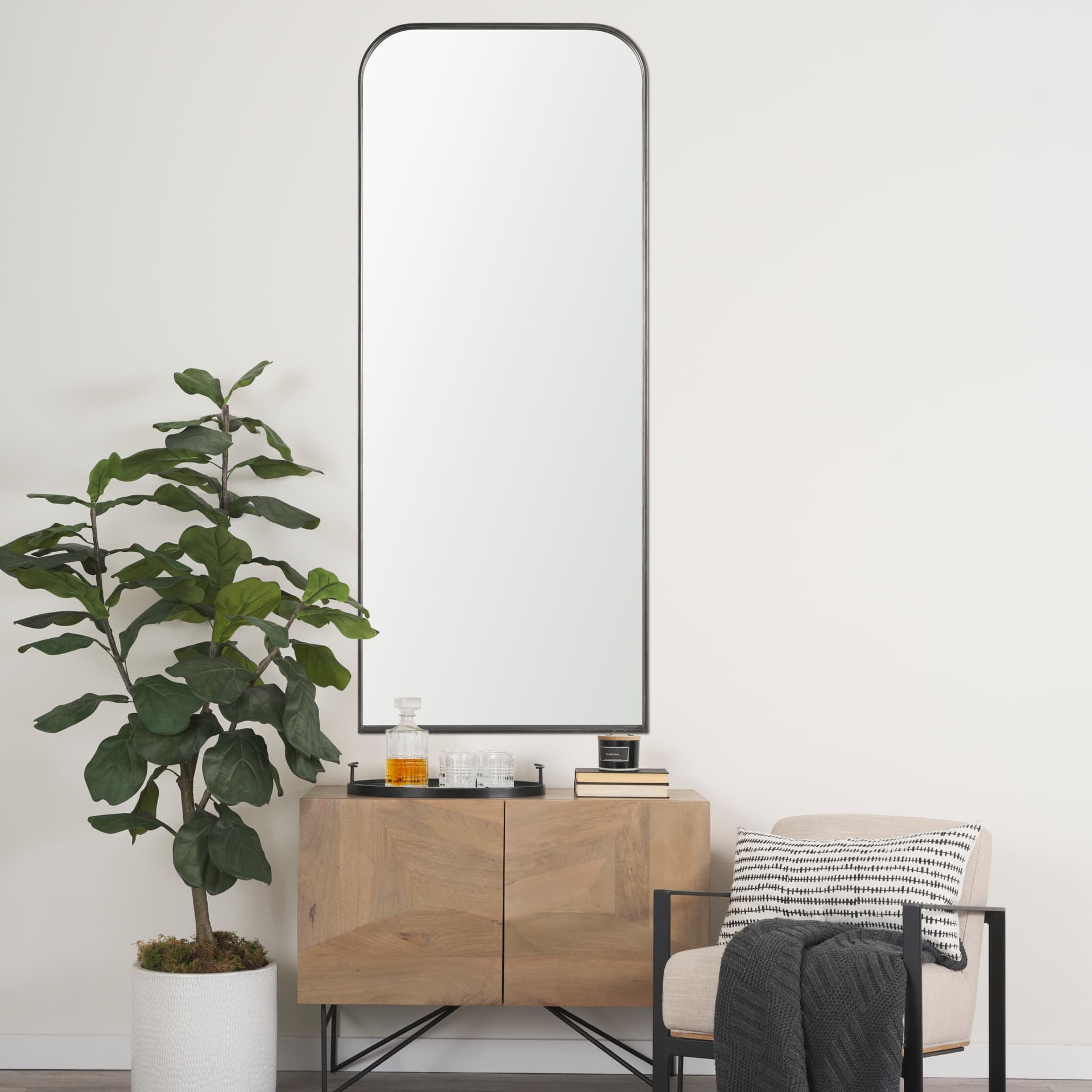Tamira Tall Brushed Gunmetal Metal Arched Mirror — in a styled room