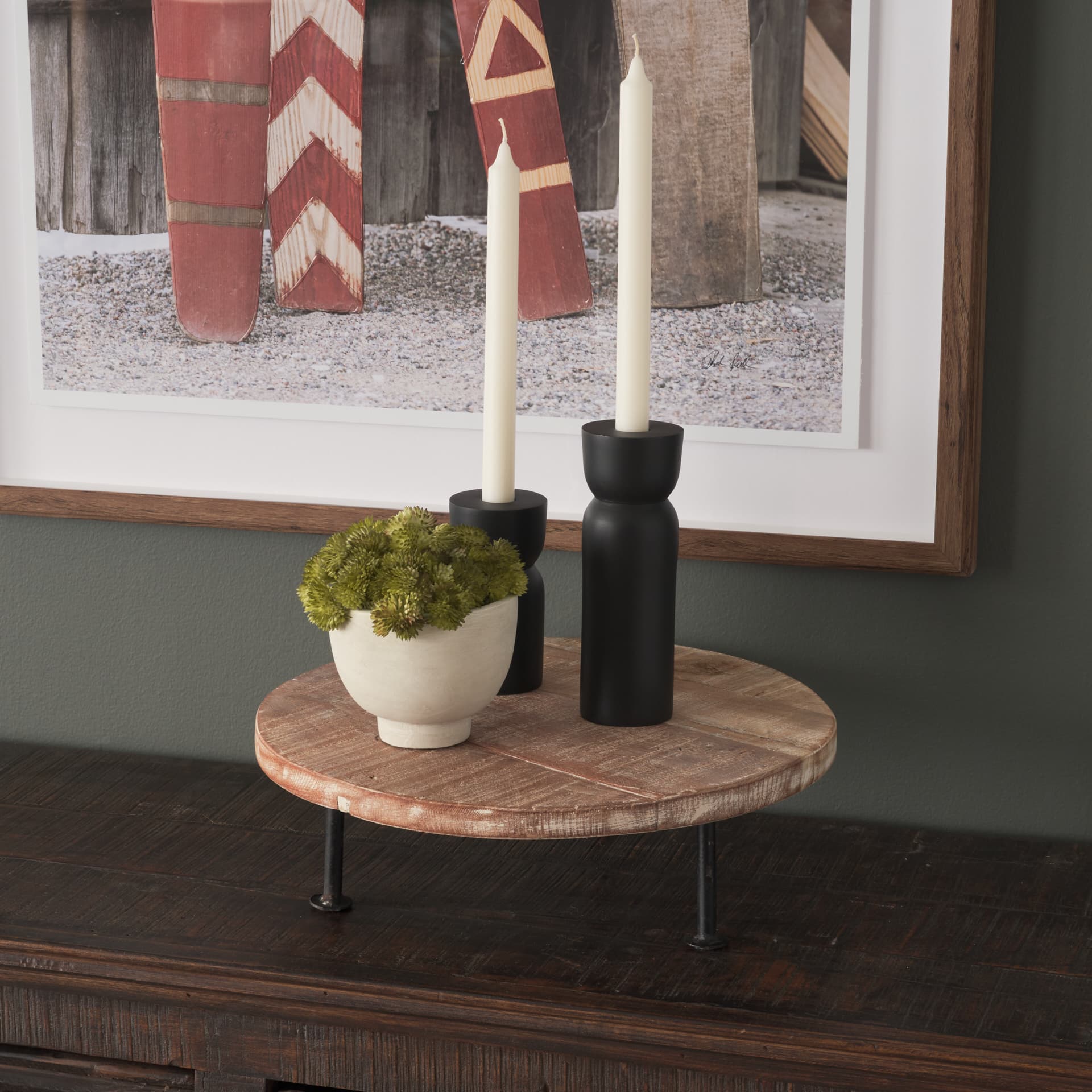Cedric 15L x 15W x 4.5H Round Light Brown Wood w/ Black Metal Legs Decorative Display Stand — in a styled room
